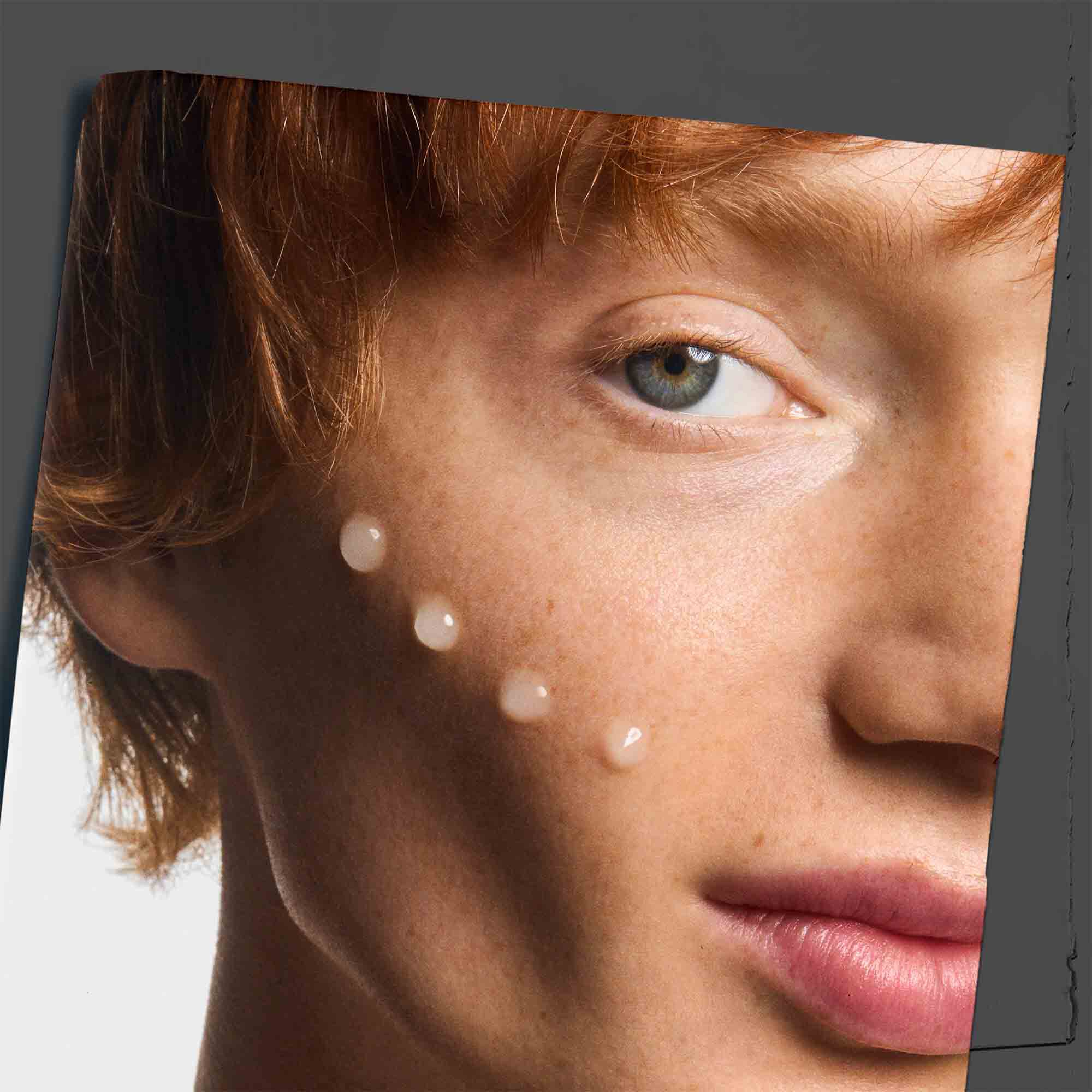 Age Defender Power Serum auf dem Wangenknochen aufgetragen, zeigt die Anwendung auf der Haut.