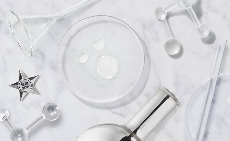 Alt-Text: Eine minimalistische Anordnung von Laborinstrumenten und Tropfen auf einer marmorierten Oberflache.