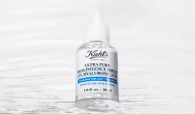 Eine Flasche Kiehl's Ultra Pure High-Potency Serum mit 15% Hyaluronsaure auf einem reflektierenden Hintergrund.