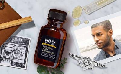 Braunflasche mit Kiehl's Bartol auf einem marmornen Untergrund, umgeben von fotografischen Elementen und einem jungen Mann.