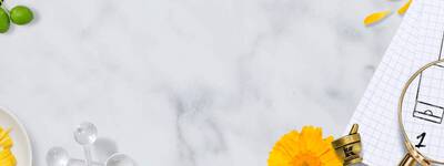 Eine helle, kreative Arbeitsoberflache mit Notizblattern, einer Lupe, Skizzen von Flaschen und gelben Blumenarrangements.