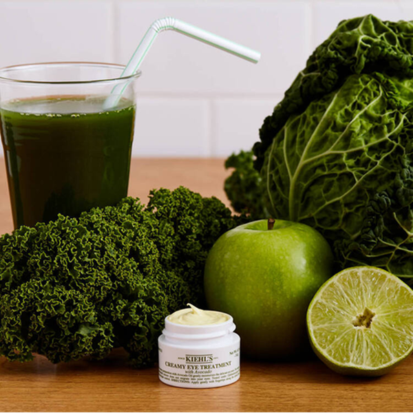 Kohl, Apfel, eine halbe Limette und Kiehl’s Augenpflege neben einem grunen Smoothie