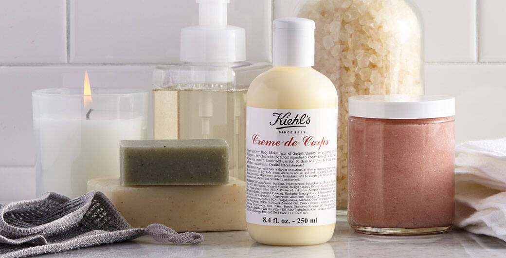 Bild der Creme de Corps Bodylotion von Kiehls im Badezimmer vor einer Kerze und Seife