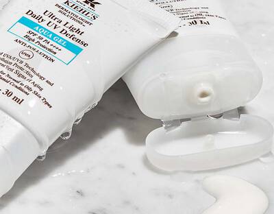 Zwei Sonnencreme liegen geoffnet ubereinander