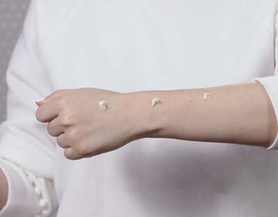 Arm mit verschiedenen Sonnencreme Proben