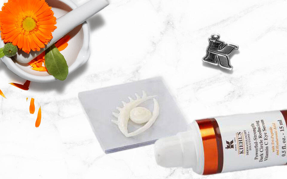 Ein Morser mit einer orangenen Blume, eine Tube mit Lotion, ein Klipp und eine Silikonform auf einer marmorierten Oberflache.