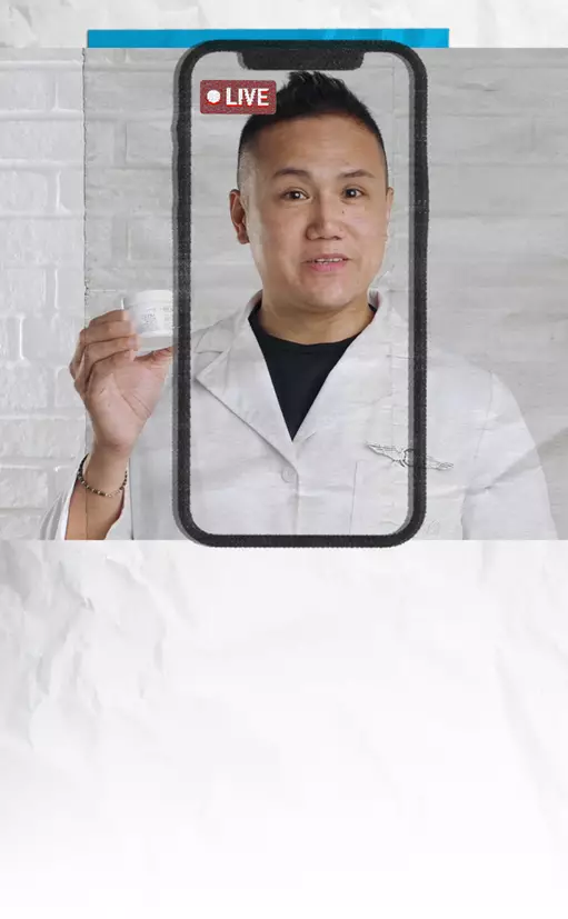 Ein Mann in einem weißen Kittel halt ein Produkt in der Hand und spricht uber ein Live-Video auf seinem Smartphone.