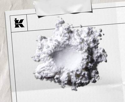 A close-up of a pipette dripping a drop of liquid into a row of petri dishes, all set against a blue-toned background.