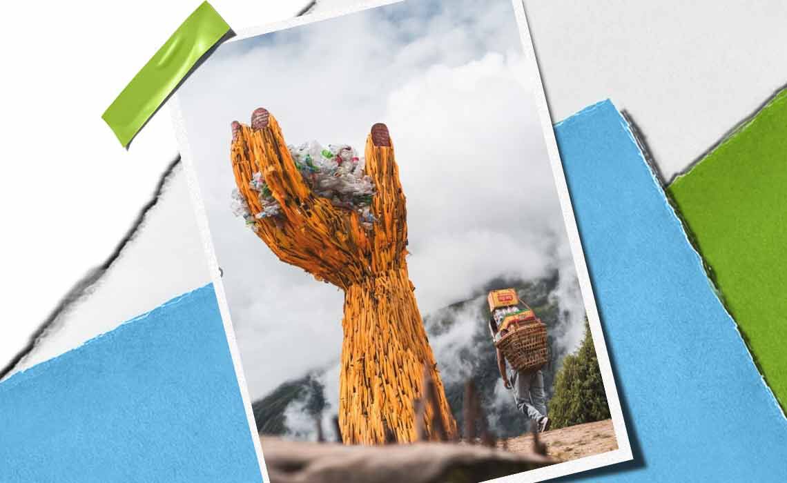 Eine hoch aufragende Holzhand-Skulptur halt einen Haufen Mull, symbolisiert Umweltbewusstsein, mit einer Person, die Waren in der Nahe tragt.