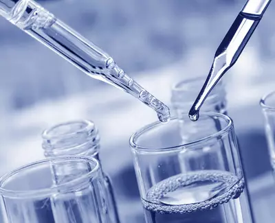Close-up of two pipettes hovering above a glass container filled with liquid, set against a blurred background. The image features shades of blue, creating a cool, scientific atmosphere.