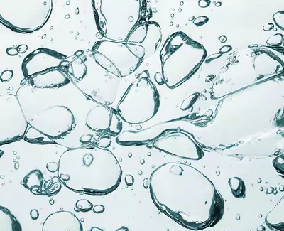 Close-up of translucent bubbles and droplets in water, creating a dynamic texture and pattern.