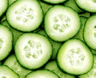 Close-up of fresh cucumber slices arranged neatly, showcasing their bright green color and seeds.