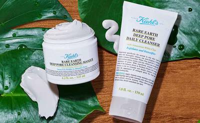 Bildbeschreibung: Zwei Kiehl's Hautpflegeprodukte auf einem Blatt. Links eine Dose mit einer Gesichtsmaske und rechts eine Tube mit einem taglichen Gesichtsreiniger.