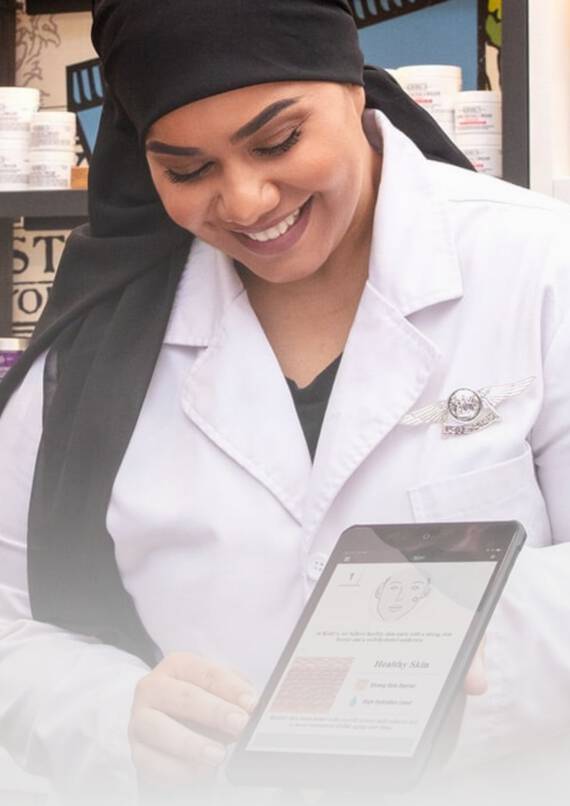 Un professionnel de la beaute appliquant un produit sur le visage d'un jeune homme, dans un environnement de soin esthetique.