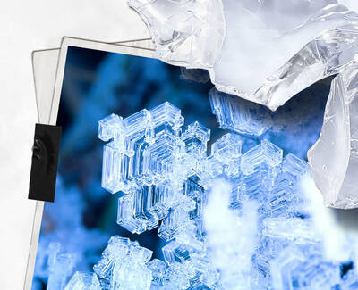 Close-up of intricate ice crystals with a bluish hue, showcasing their geometric shapes and delicate structures.