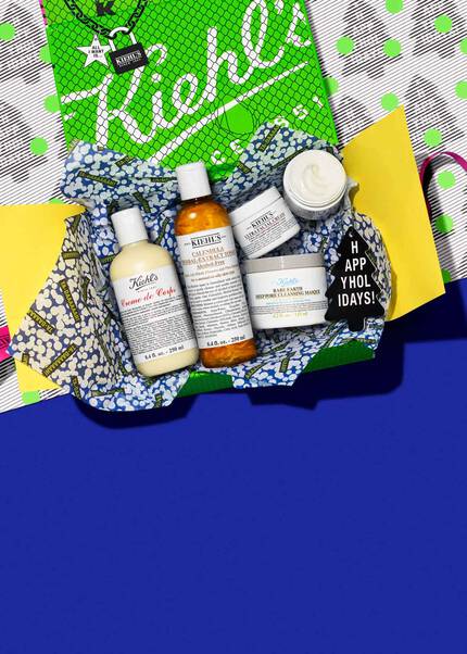 Un assortiment de produits de soin dans un paquet colore, comprenant des bouteilles de shampooing, de revitalisant et d’autres soins, sur un fond bleu.