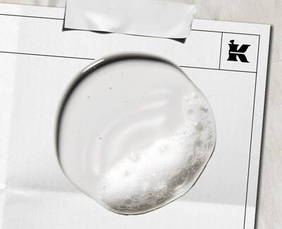 Close-up of green olives growing on an olive tree branch, surrounded by slender leaves.